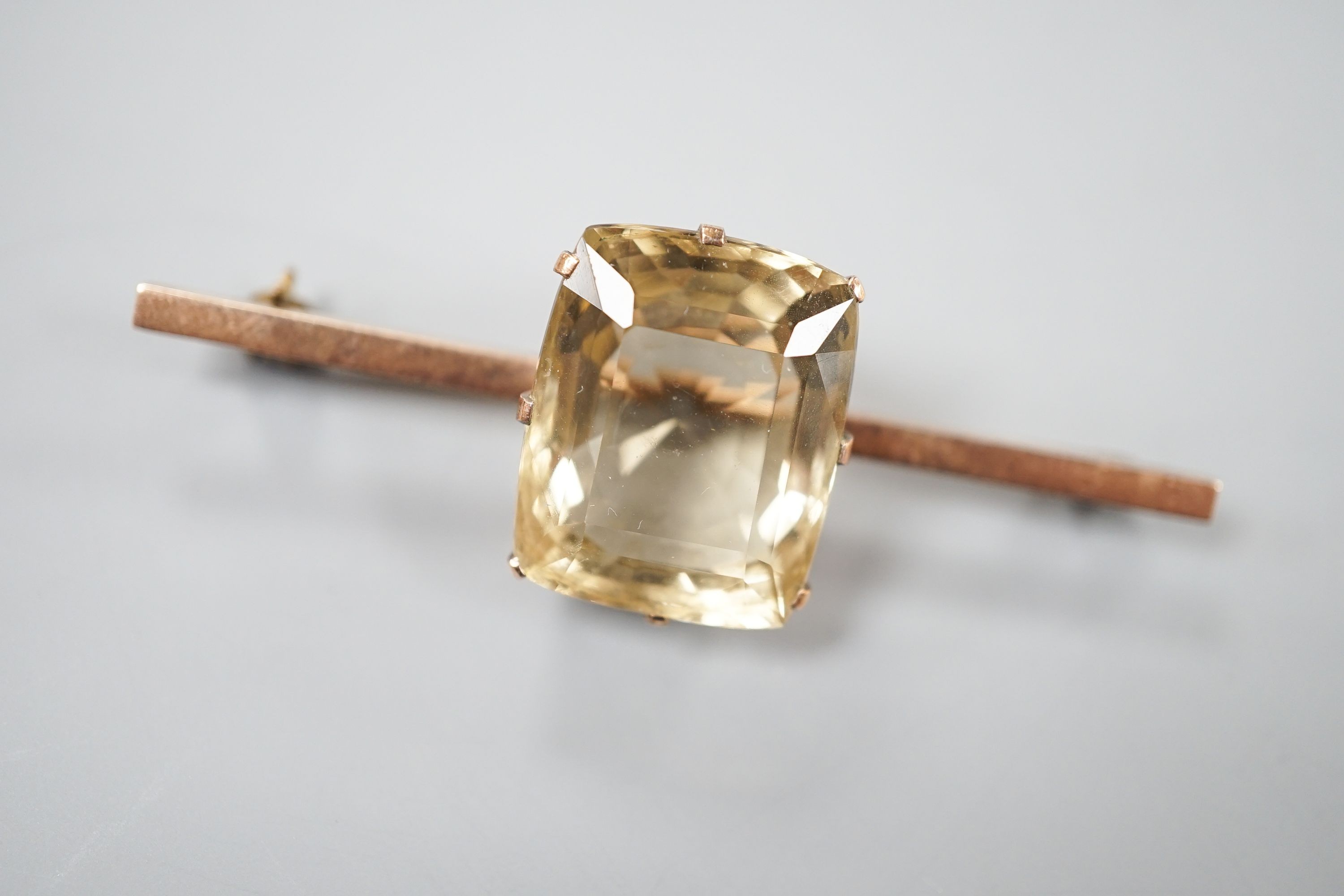 A yellow metal and citrine set bar brooch, 61mm, gross weight 11.9 grams.